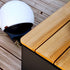 SACKit Patio Storage Table i teak og svart aluminium med oppbevaringsrom, designet for utendørs bruk.