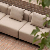 Beige modulbasert loungesofa med myke puter på teglterrasse fra sackit for et stilrent nordisk uterom