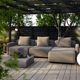 Modulær lounge sofa med pouf og beige puter på en treterrasse under pergola i en frodig hage fra sackitarsuaq