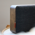 Bluetooth-høyttaler i naturlig eik med Fiord-tekstil fra KVADRAT og messingdetaljer.