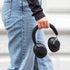sackit Touch 310 hodetelefoner i svart holdes i hånden av en person iført jeans og svart genser