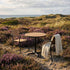 Kirra Café Table utendørs spisebord i pulverlakkert aluminium og ubehandlet teak med rund bordplate.