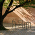Kirra Patio Lounge Chair i olivengrønn med pulverlakkert aluminium og ubehandlet teaktre, utendørs setting.