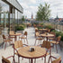 Kirra Café Table utendørs spisebord i pulverlakkert aluminium og ubehandlet teak med rund bordplate.