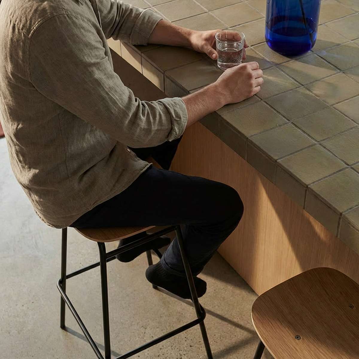 Frame Bar Stool barkrakk med sete i eikefinér og svart pulverlakkert stålramme, industrielt design.