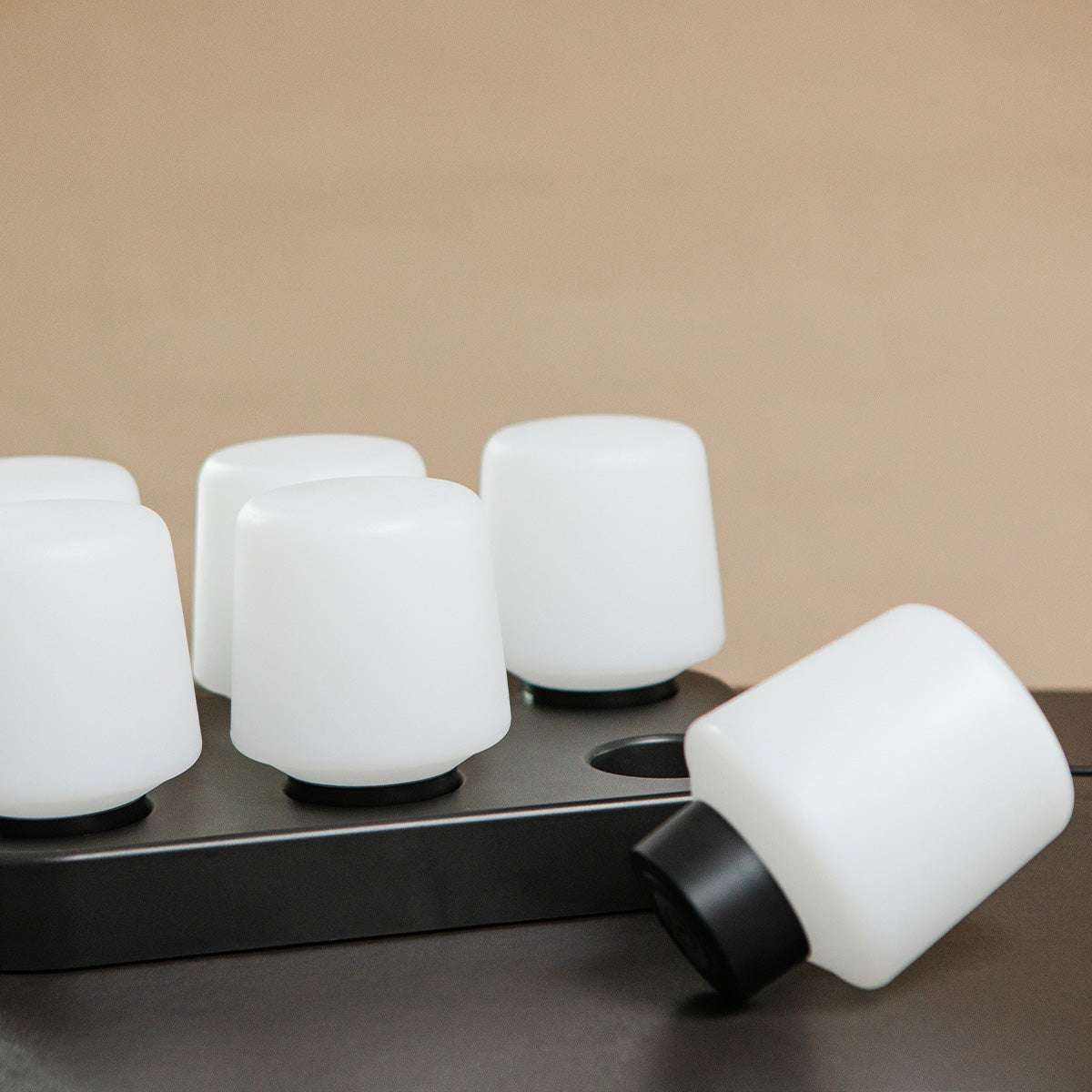 Svart ladestasjon i ABS-plast for opptil seks Lamp Intelligent lamper, kompakt og rektangulær.