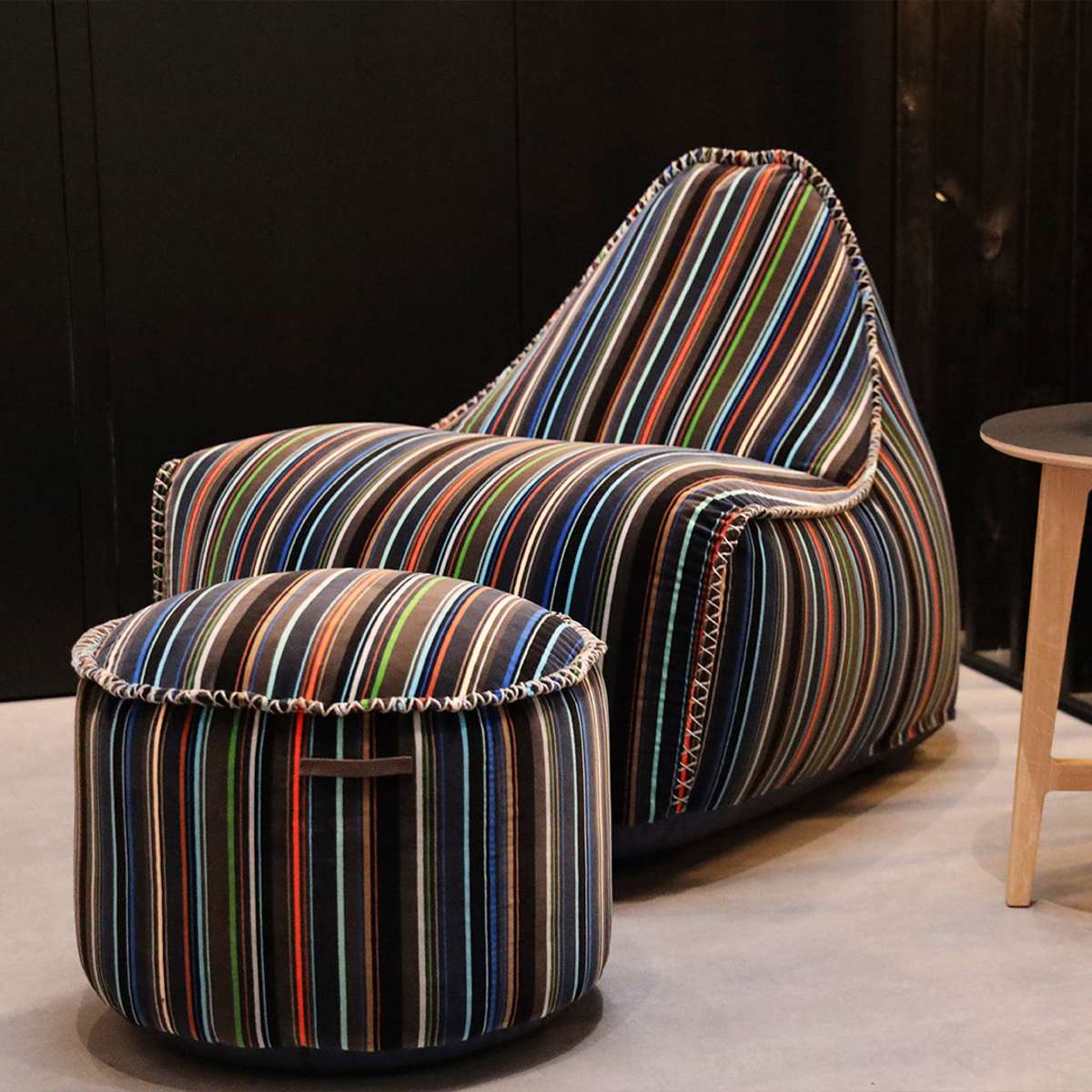 Lounge Chair & Pouf Paul Smith med flerfarget bomullstrekk i moderne, lineært design på lyst gulv