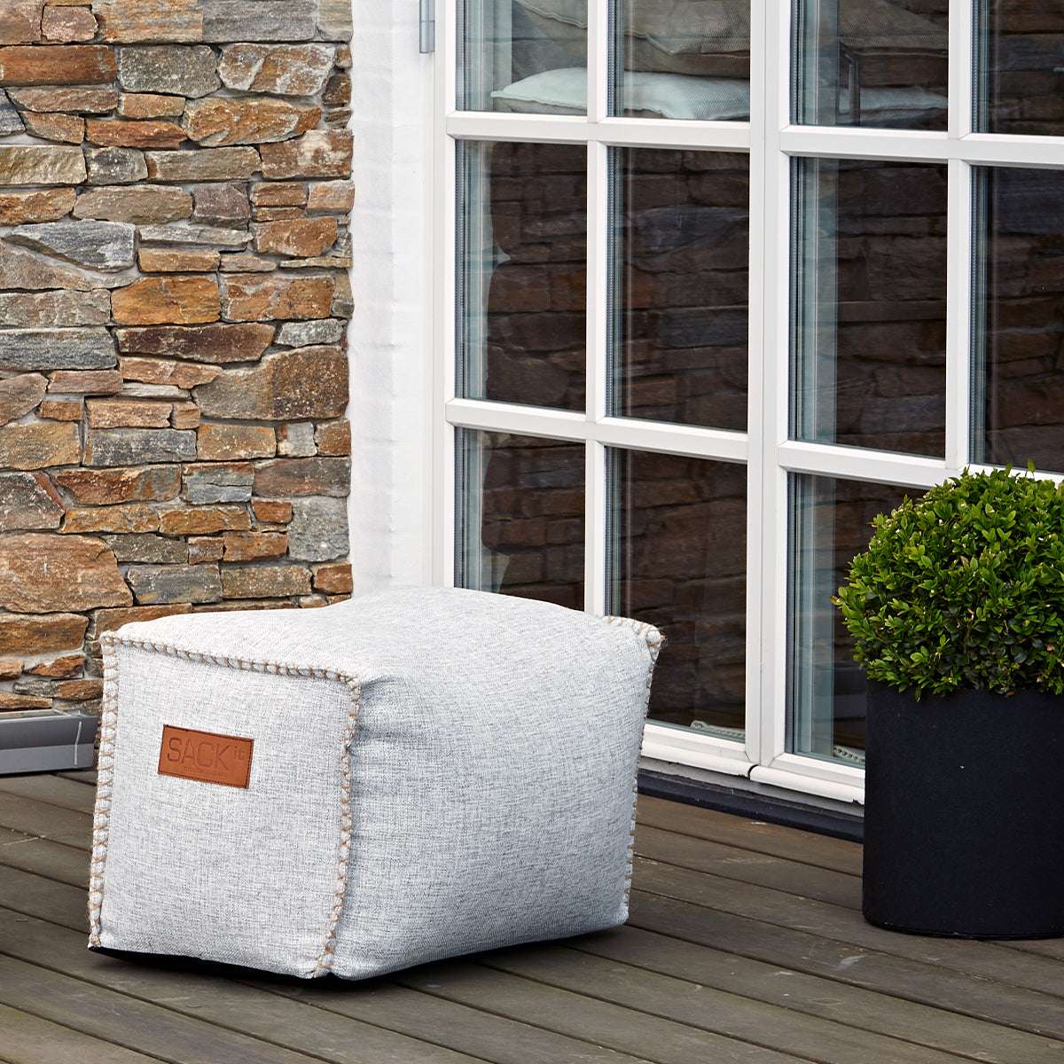 Cobana Square Pouf i svart olefinfiber med firkantet form og håndsydde sømmer.