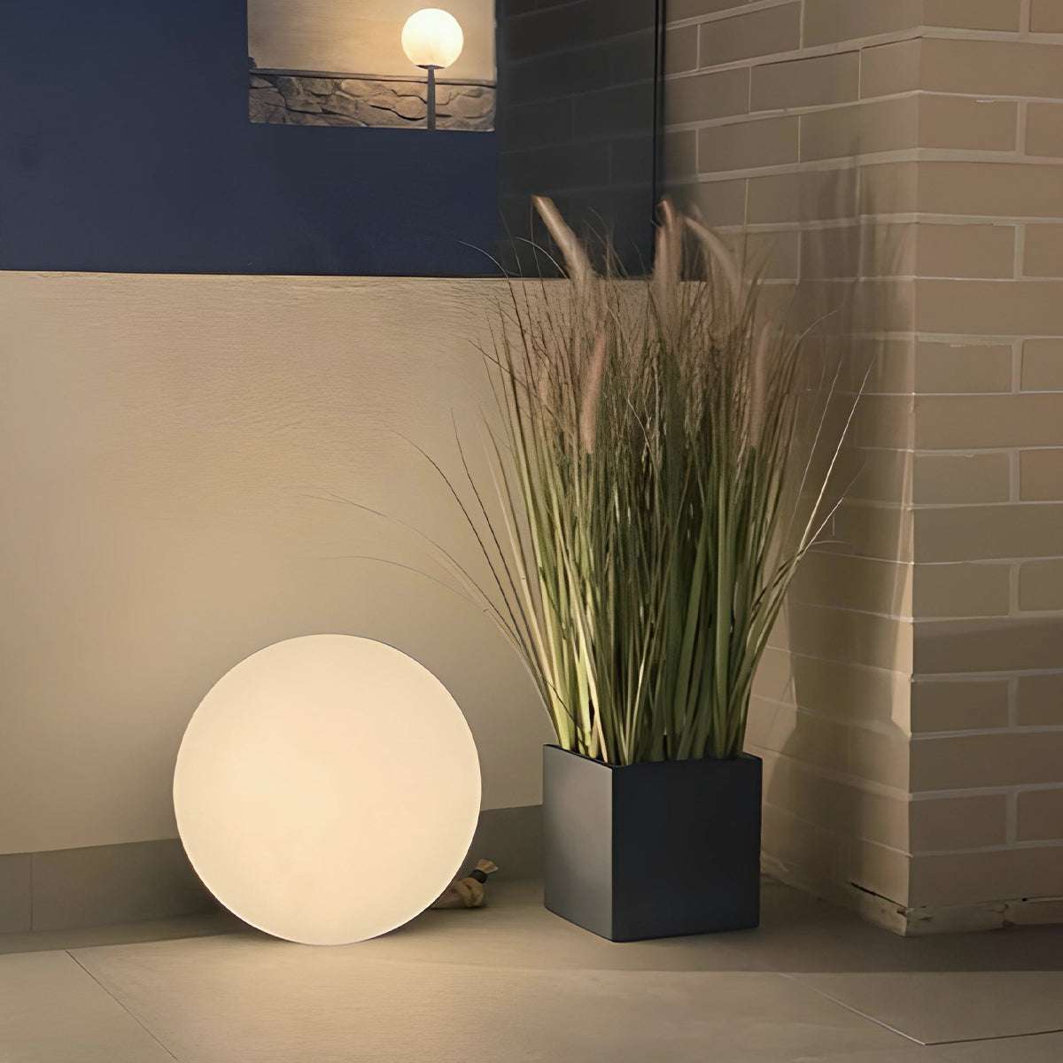 SACKit Light 350 utendørslampe med rund hvit lyskule og håndtak i hamp-tau, plassert i utendørsmiljø.