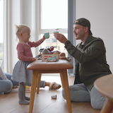 Nordic Bench in oak with Terra Black leather seat and smooth wooden frame in natural setting