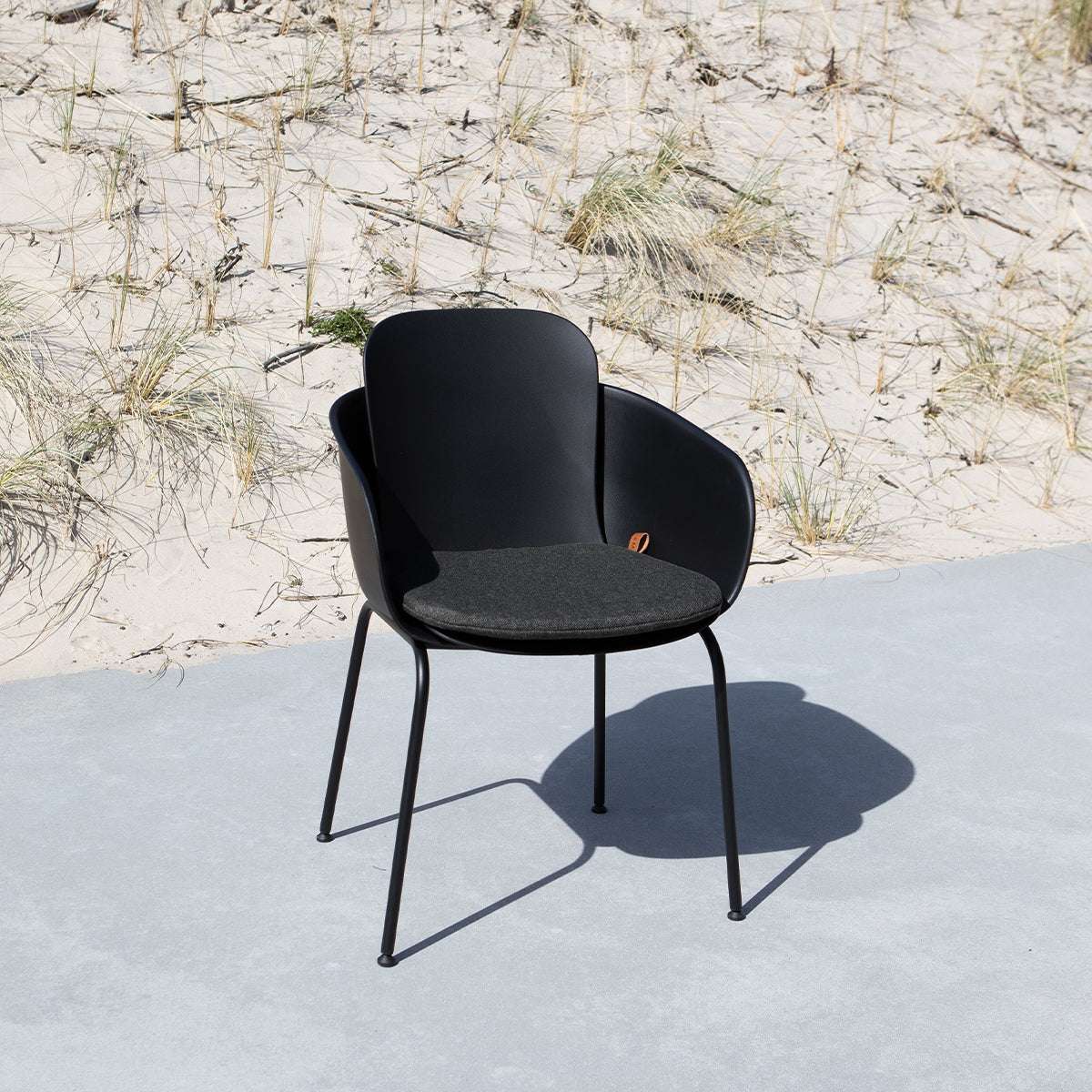 Svart Patio Chair no. One pute i olefinfiber med sklisikker bakside på trestol utendørs.