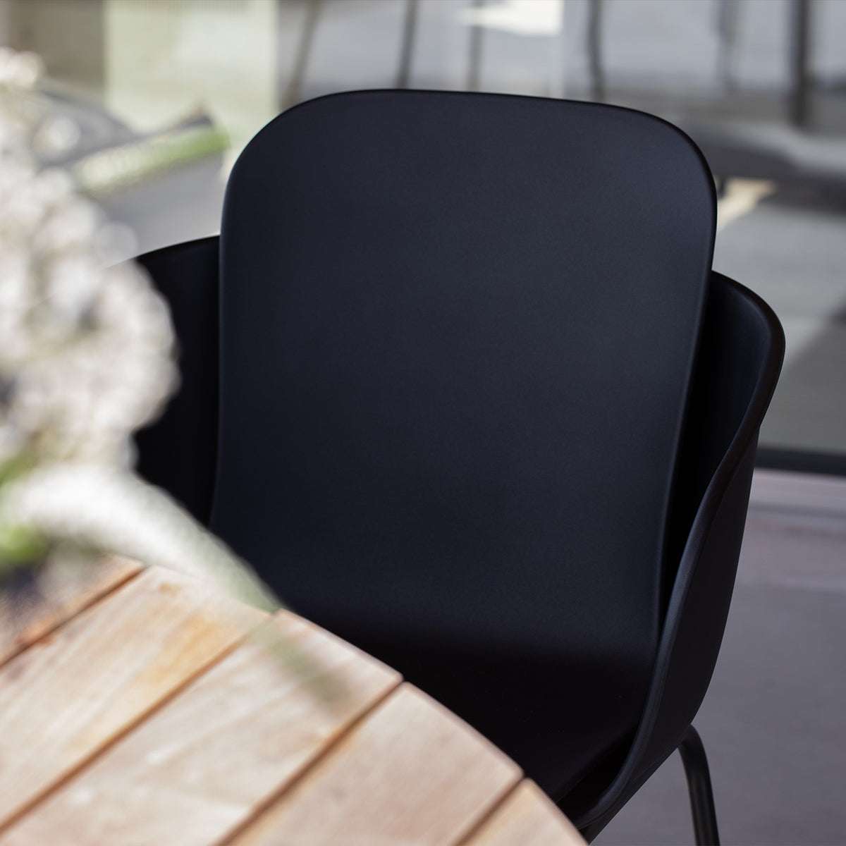 Taupe Patio Chair no. One S2 with black frame made of recycled plastic and steel, outdoor setting.