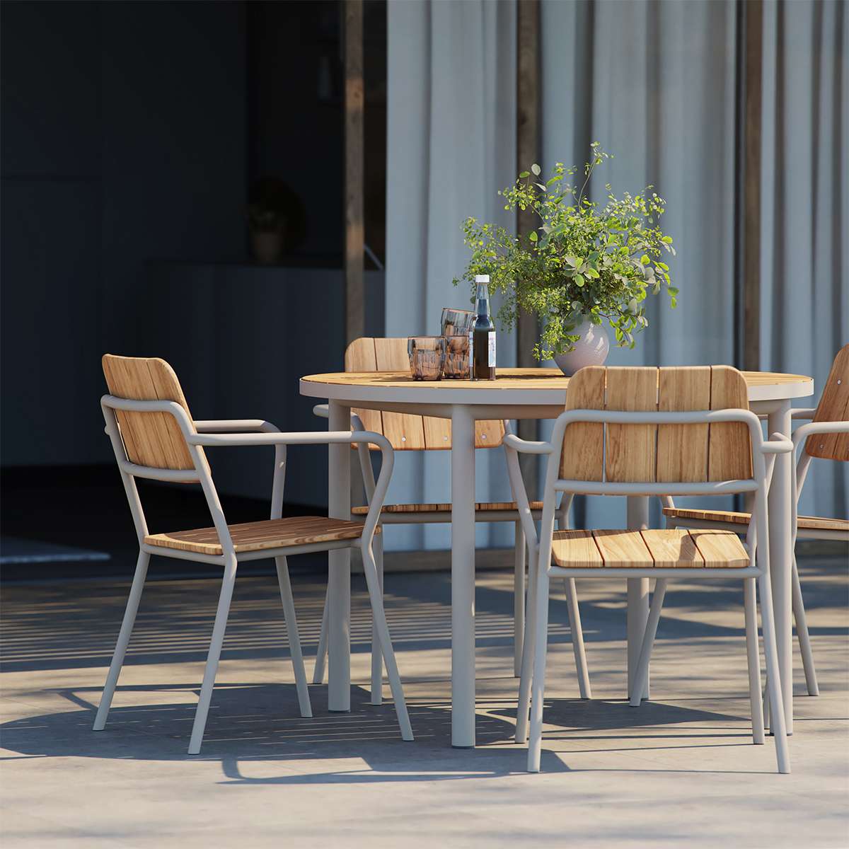 Kirra Dining Table Ø110 i taupe pulverlakkert aluminium med ubehandlet teakplate utendørs.