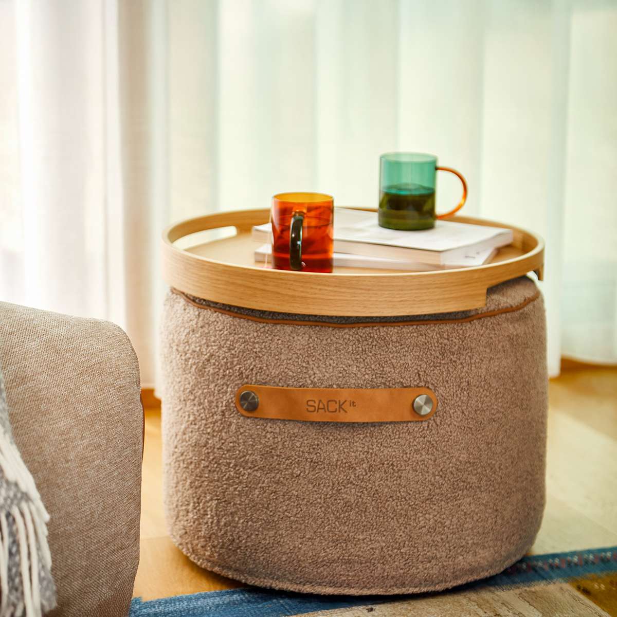 SACKit Pouf Indoor i Teddy Brown tekstil, rund puf med myk kaldskumfylling og sklisikre punkter.