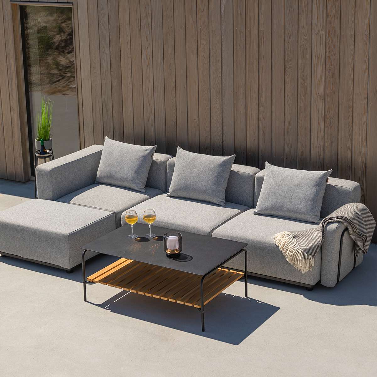 Svart Cobana Lounge Sofa med tre moduler uten armlener og puff i moderne utendørsdesign.