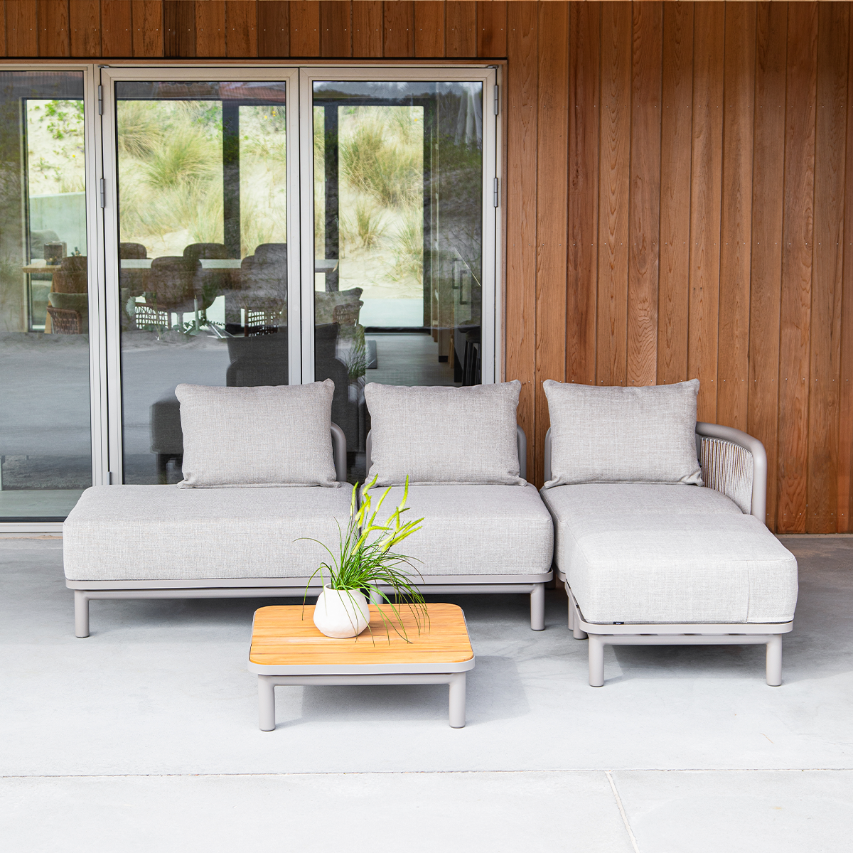 Kirra Lounge Sofa i sandfarge med åpen høyre ende i pulverlakkert aluminium og olefin-tekstiler.