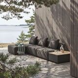 Modulbasert Cobana loungesofa fra sackit på treterrasse ved sjøen med mørke puter puff og sidebord i et nordisk utemiljø
