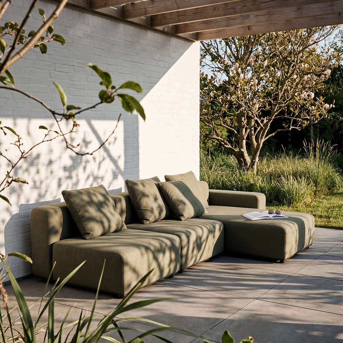 sackit modulbasert loungesofa med sjeselong i dempet olivengrønn tekstil på en solrik terrasse med skandinavisk uttrykk og utsikt til hagen