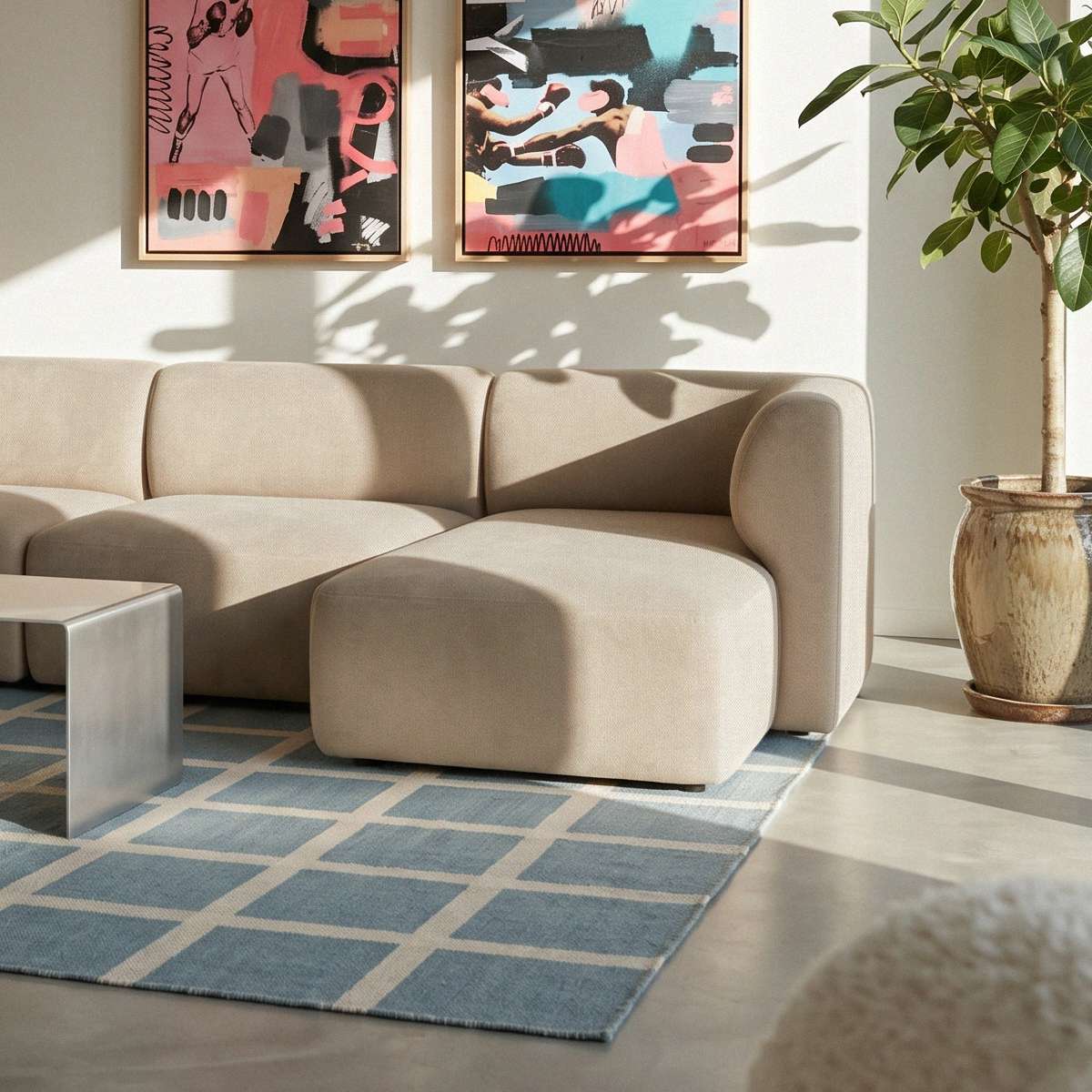 Beige Fjord sofa med høyrevendt sjeselong fra sackit i en lys stue med abstrakt kunst grønne planter og blått geometrisk teppe