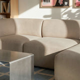 Beige Fjord sofa med tre sitteplasser og høyre sjeselong fra sackit i et lyst skandinavisk interiør med salongbord og kunst på veggen
