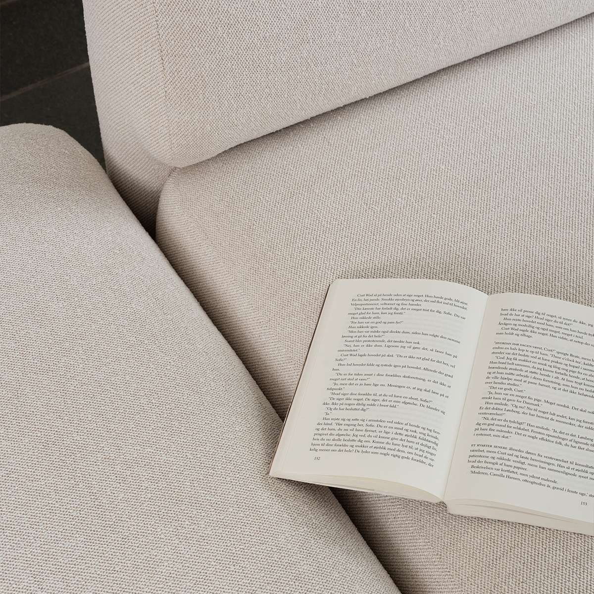 Beige Fjord sofa fra sackit med myke avrundede former og åpen bok på setet i et rolig skandinavisk interiør
