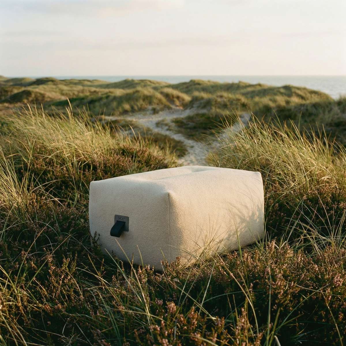 Soft Sofa Outdoor pouf i boucle beige stoff med myk, rund form for utebruk.