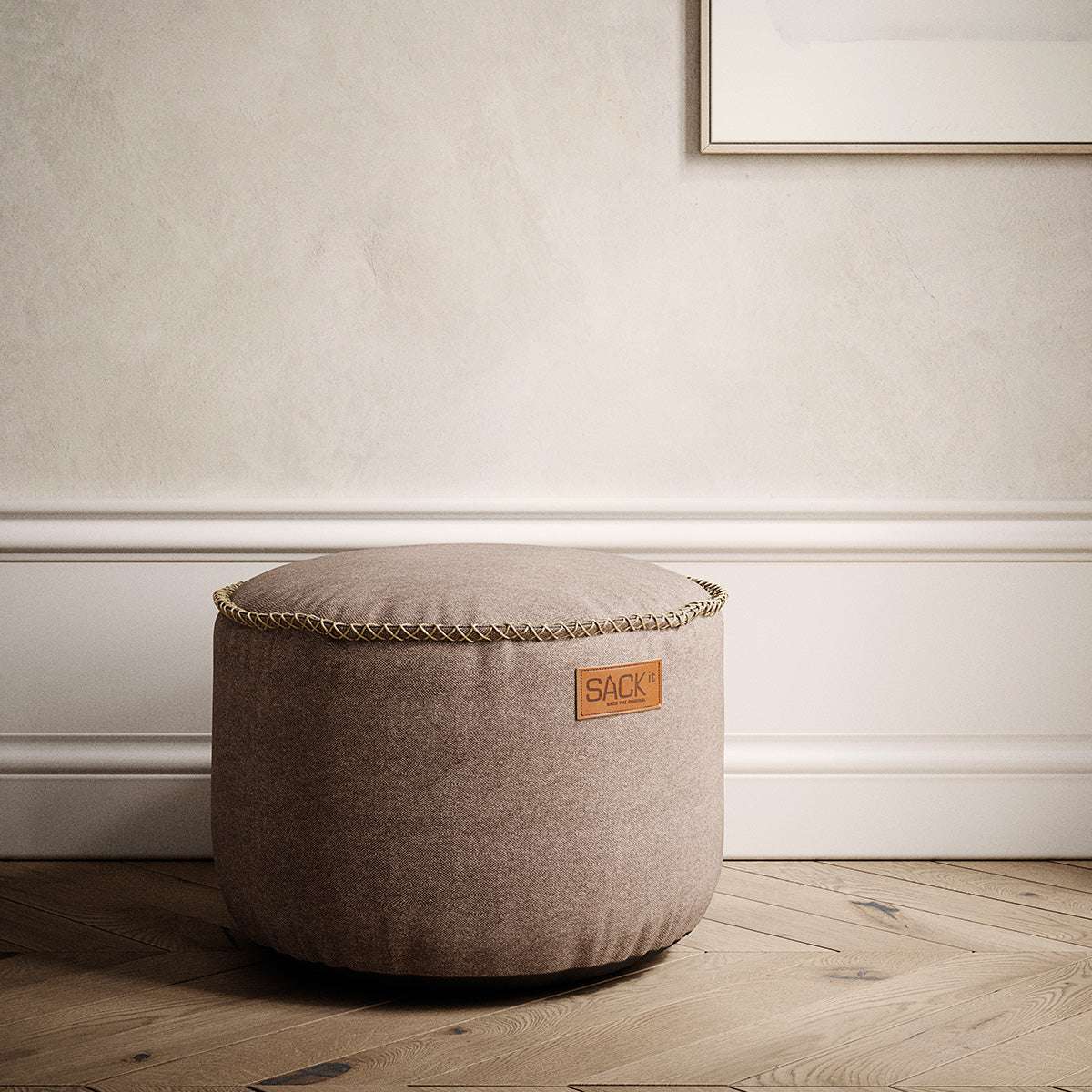 Rund canvaspuff i varm beige tekstil fra sackit i elegant nordisk interiør med klassiske detaljer og lyst tregulv