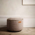 Rund canvaspuff i varm beige tekstil fra sackit i elegant nordisk interiør med klassiske detaljer og lyst tregulv