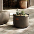 Rund Cobana Pouf i grått vannavstøtende stoff med håndsydde sømmer.