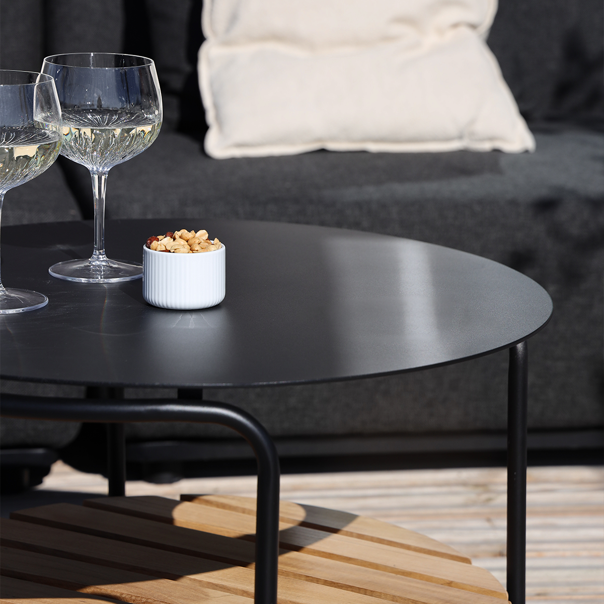 Rundt utendørs sofabord i sort pulverlakkert aluminium med teak bordplate, dansk design.