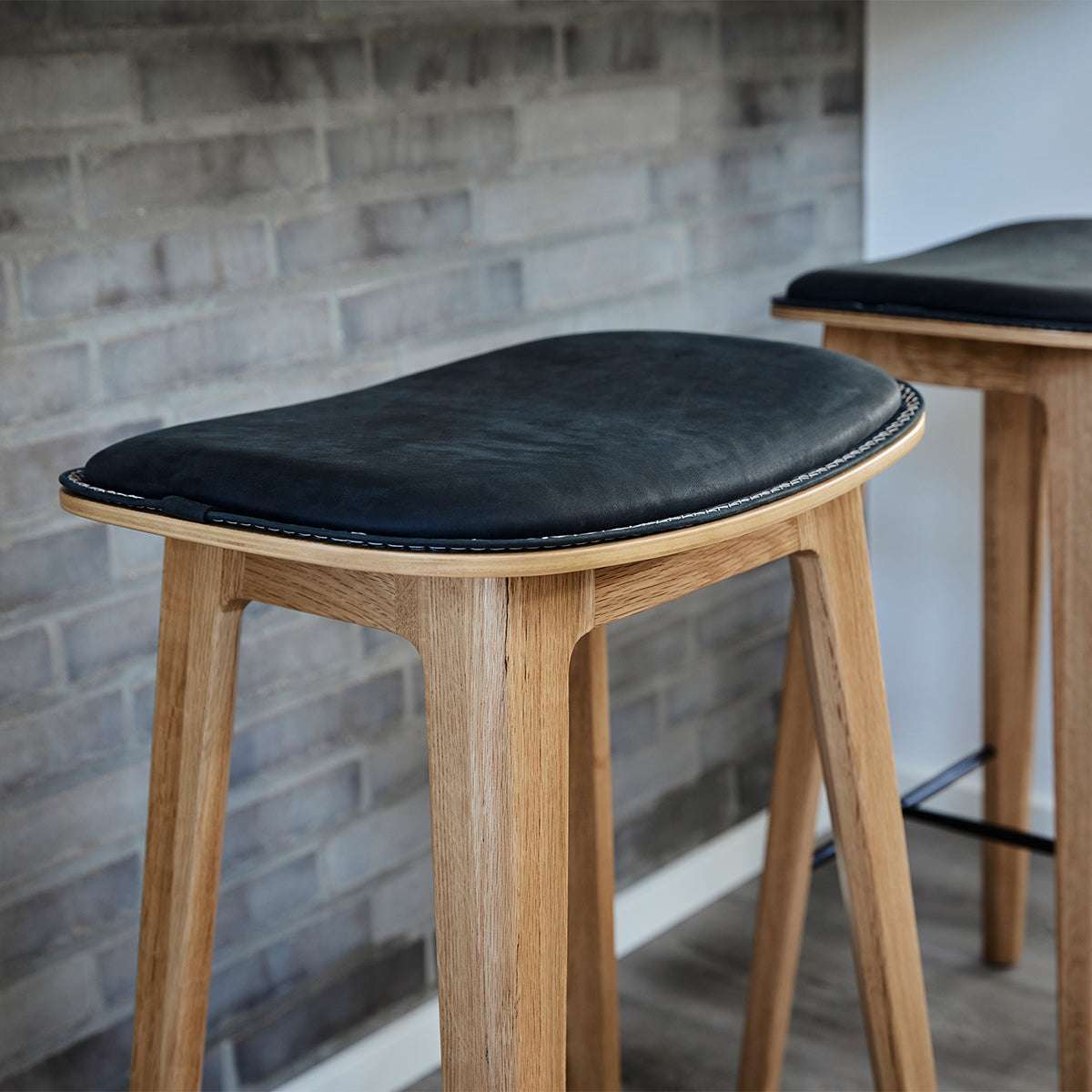 Nordic Bar Stool i eik med Luna Carbon skinn og mørke kryssømmer, høyde 73 cm.