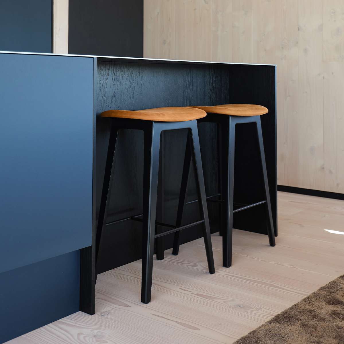 Nordic Bar Stool in black stained oak with Terra Black leather seat and steel footrest.