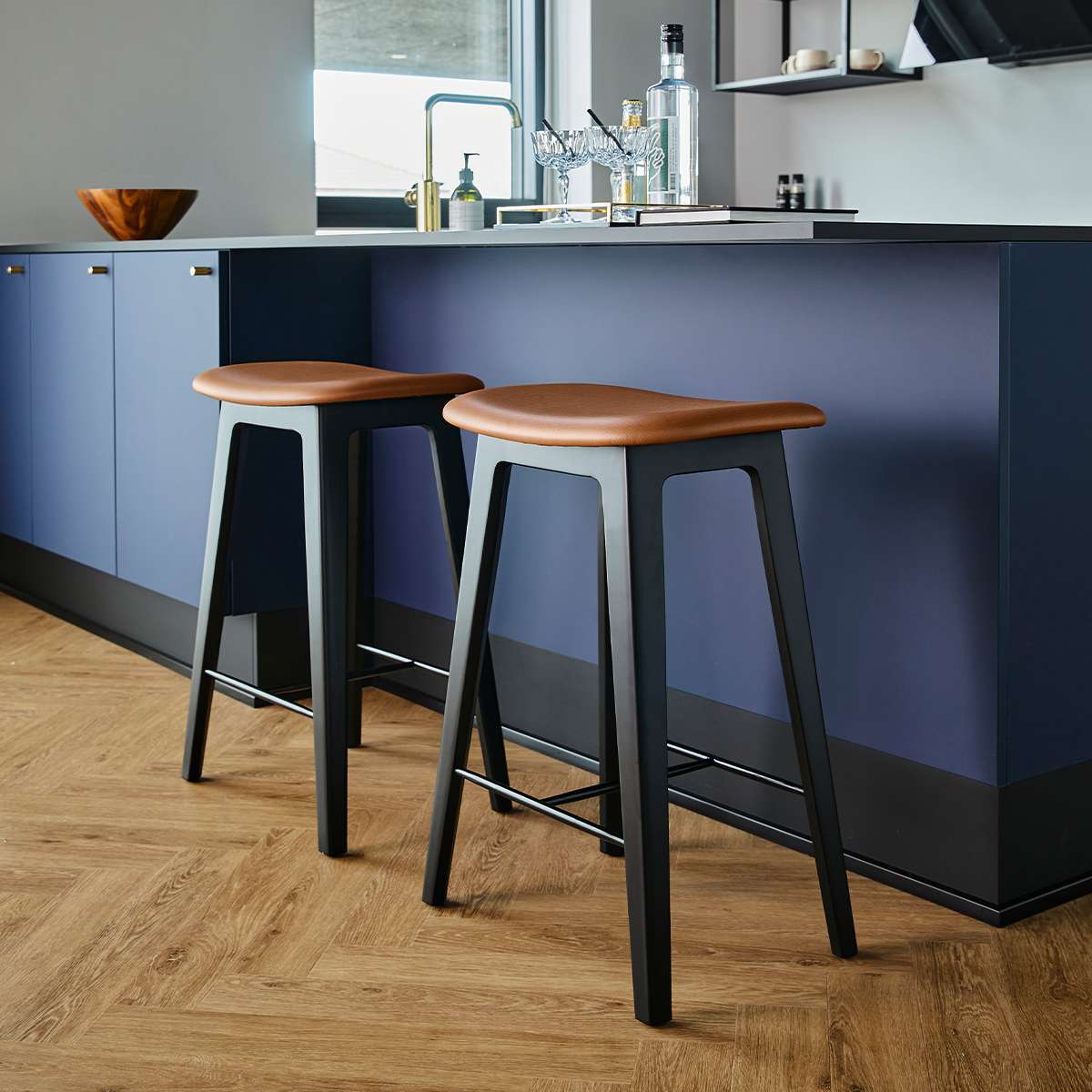 Nordic Bar Stool in black stained oak with Terra Black leather seat and steel footrest.