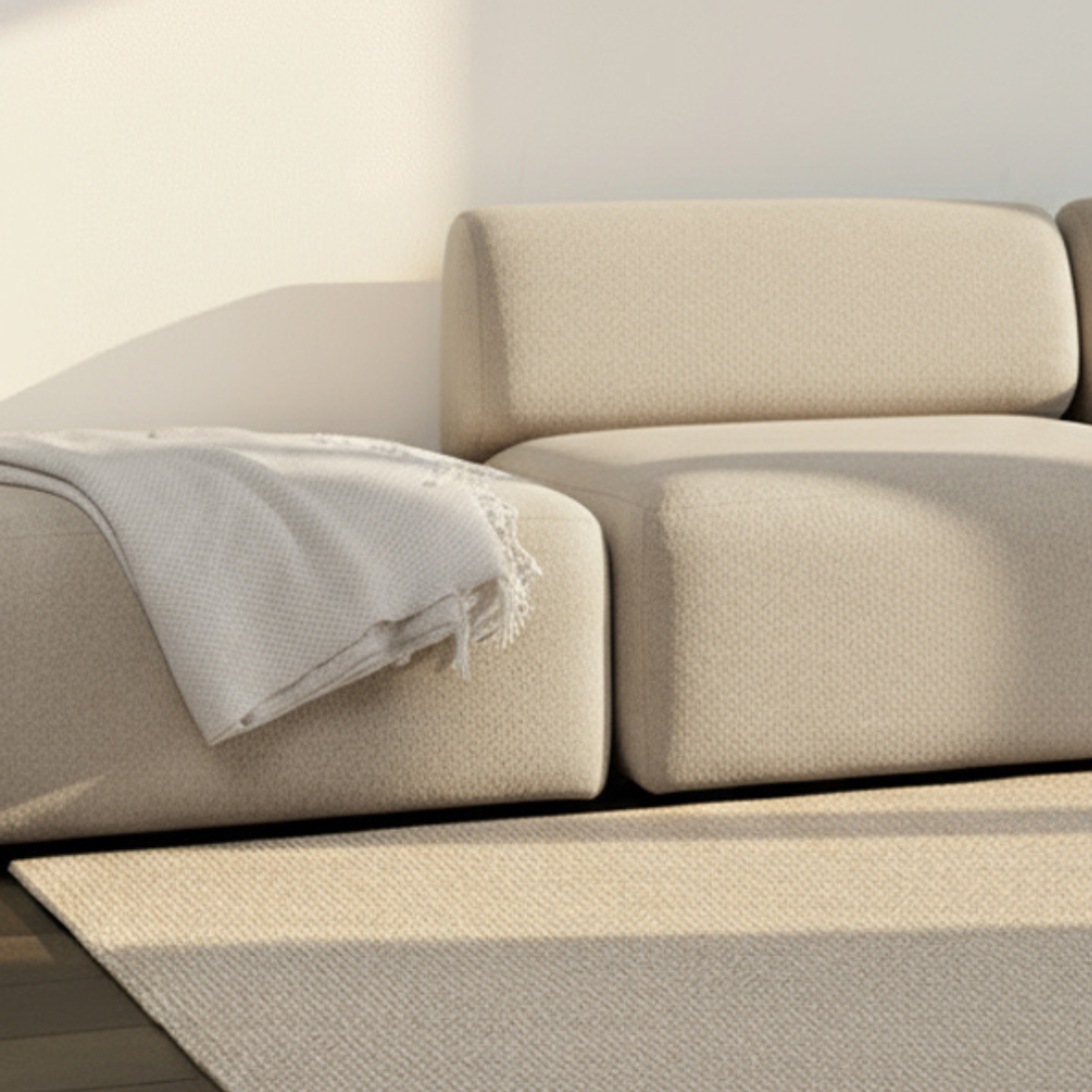 Fjord Sofa pouf i myk beige tekstil med avrundede kanter og skandinavisk design.
