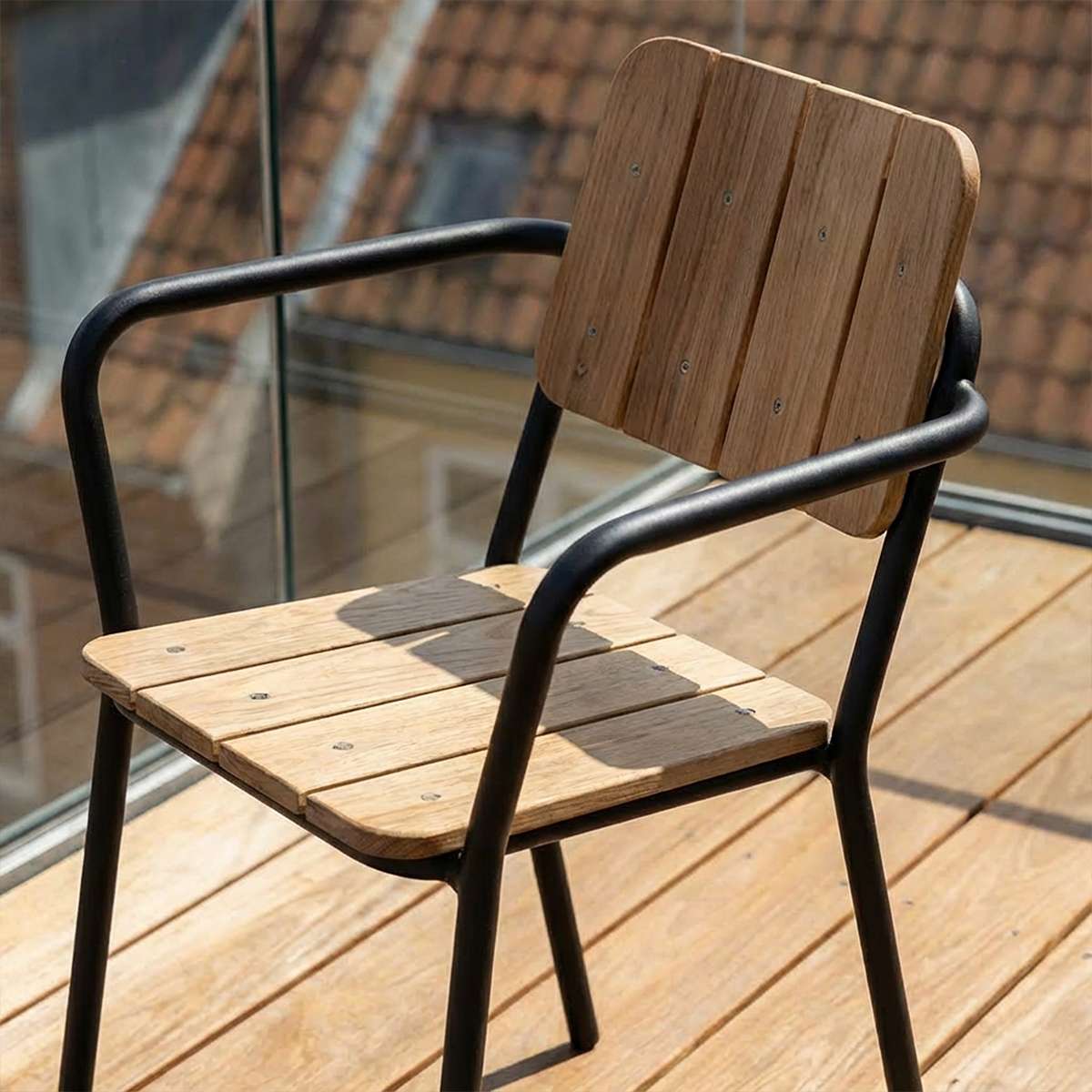 Elegant hagestol fra sackit med sete og rygg i teak og sort pulverlakkert aluminium på en solrik balkong