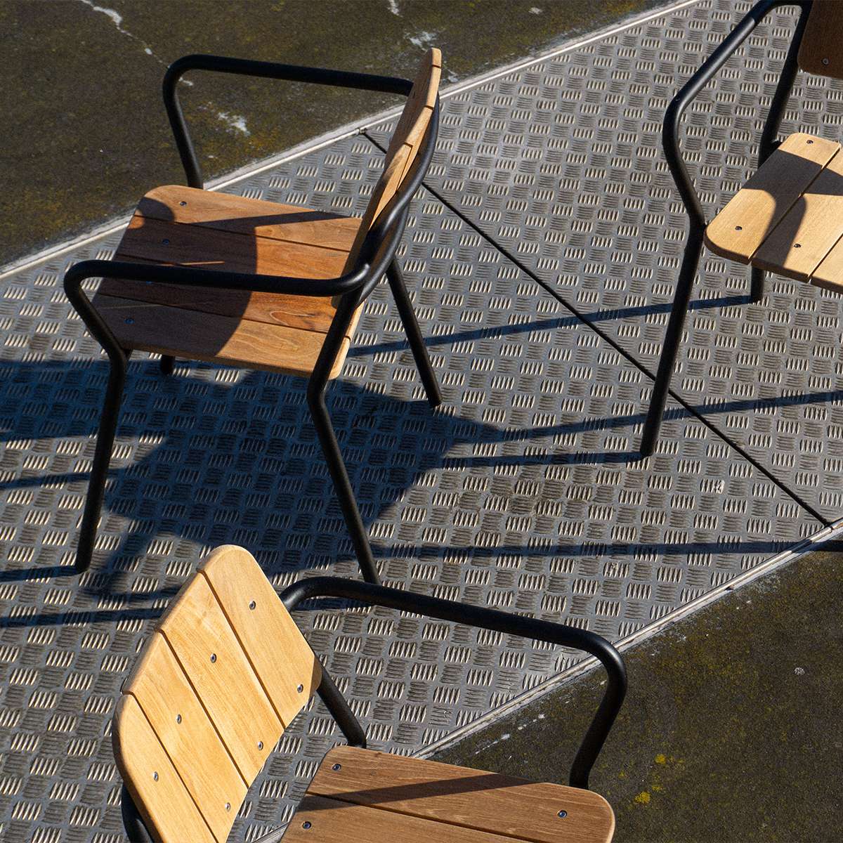 Svart Kirra Patio Chair i pulverlakkert aluminium og ubehandlet teaktre, utendørs hagestol.