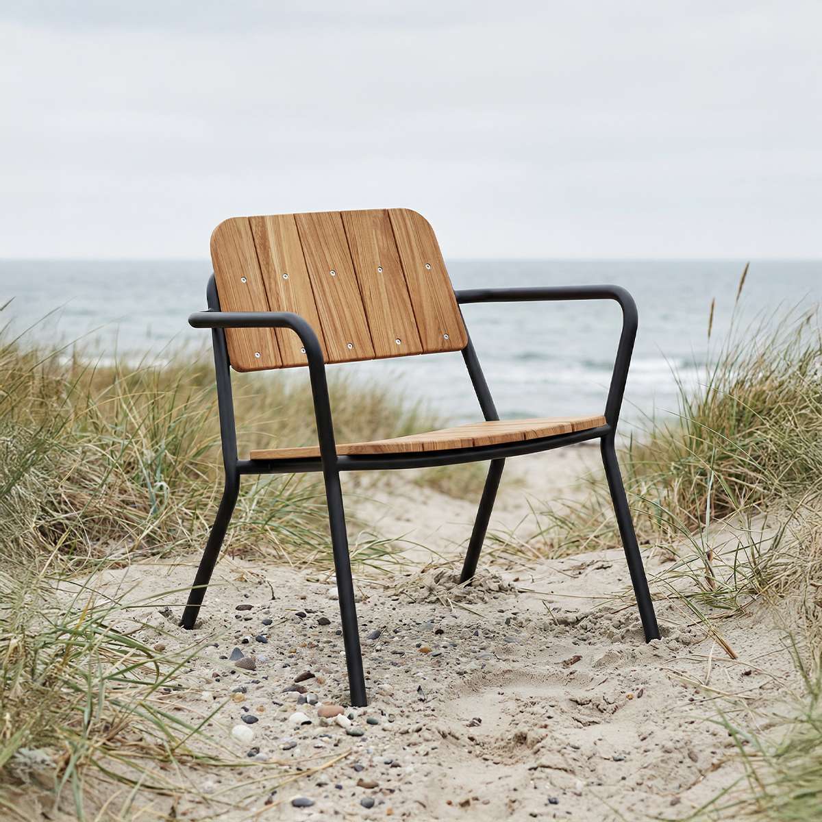 Kirra Patio Lounge Chair i svart pulverlakkert aluminium og ubehandlet teaktre, utendørs stol med lav rygg.