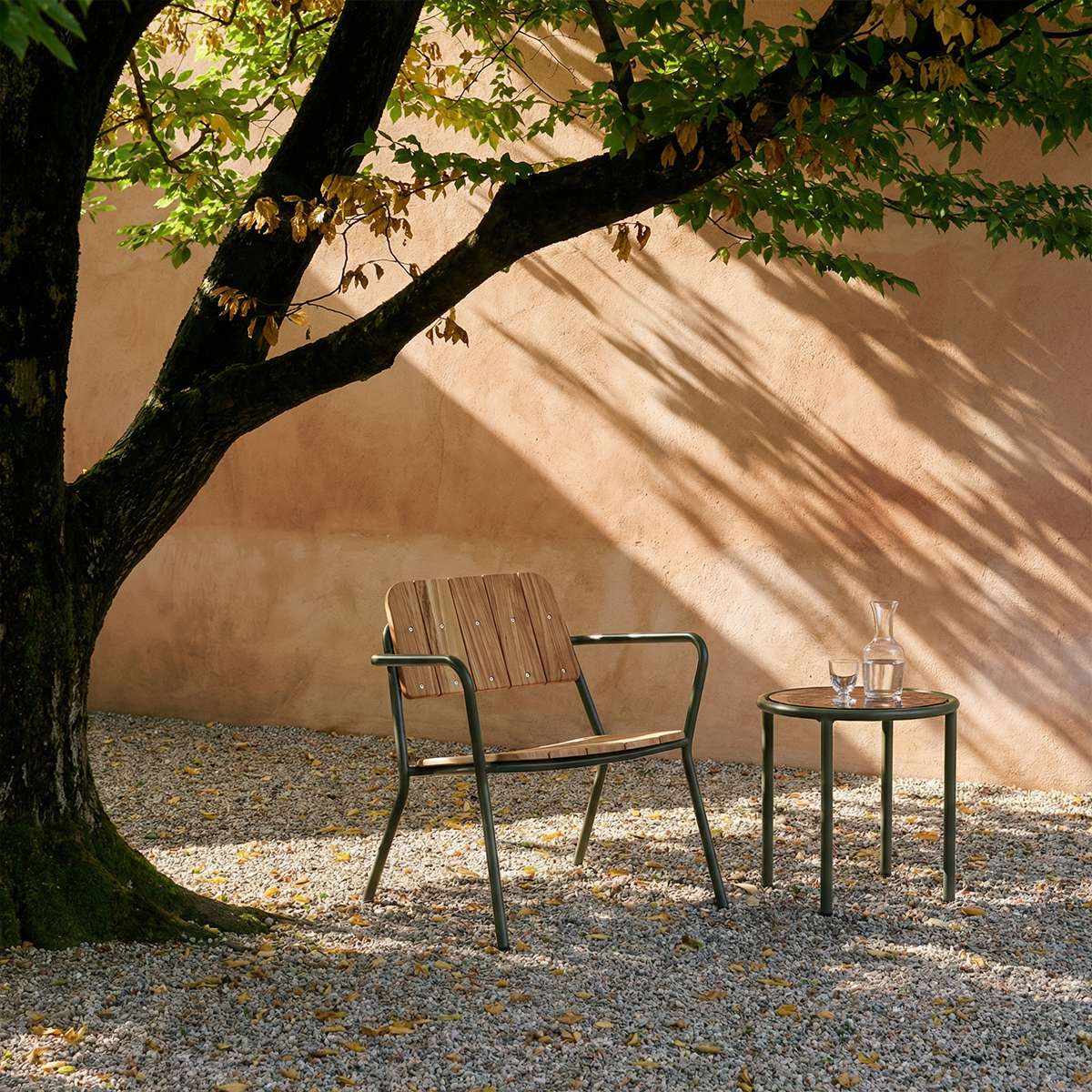 Kirra Patio Lounge Chair i olivengrønn med pulverlakkert aluminium og ubehandlet teaktre, utendørs setting.