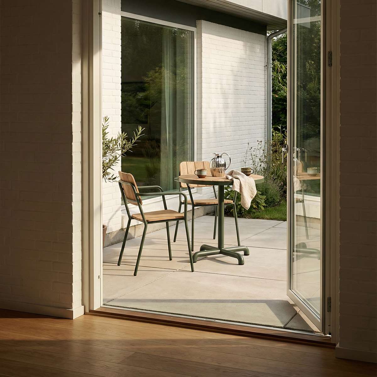 Kirra Café Table utendørs spisebord i pulverlakkert aluminium og ubehandlet teaktre med rund bordplate.