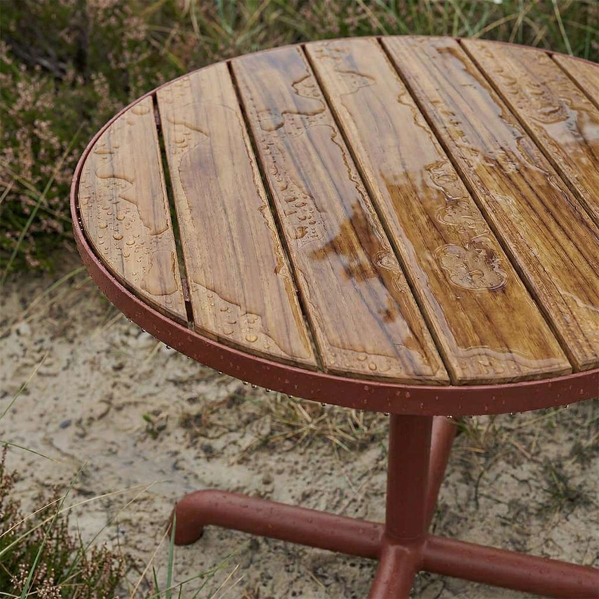 Kirra Café Table utendørs bord i pulverlakkert aluminium med teak bordplate, rund form.