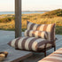 Mollis Lounge Chair i Renesse Chestnut med pulverlakkert aluminiumsramme og eco-sertifisert tekstil i uterom.