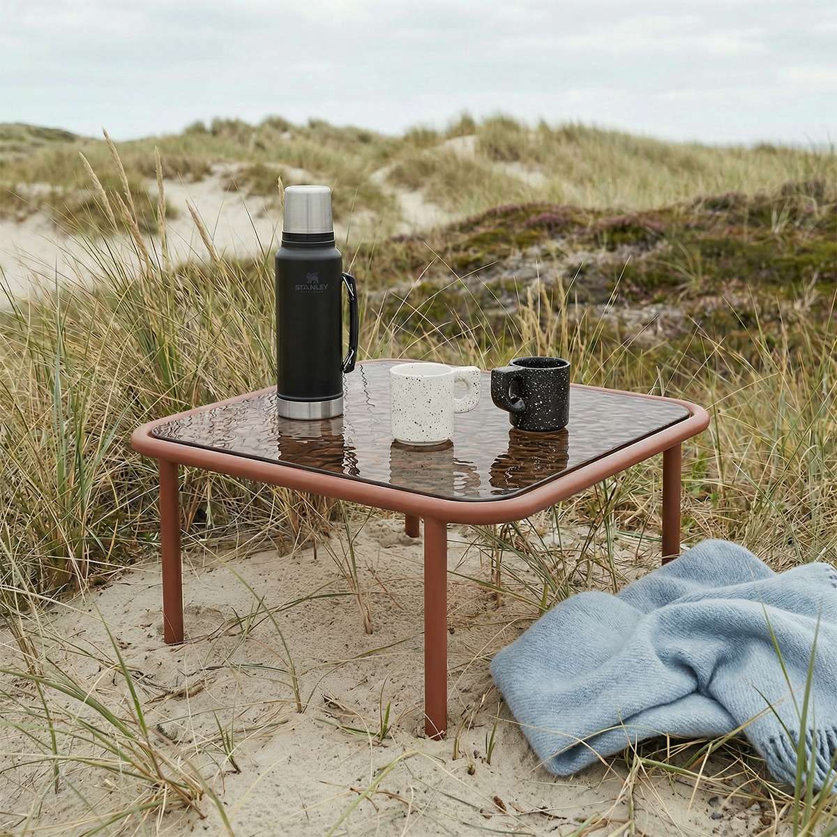 Mollis Coffee Table i chestnut farge med pulverlakkert aluminiumsramme og røykfarget herdet glassplate.