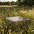 Taupe Mollis Coffee Table med pulverlakkert aluminiumsramme og røykfarget herdet glass, utendørs.