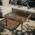 Mollis Coffee Table i olivengrønn med pulverlakkert aluminiumsramme og røykfarget herdet glass, utendørs.