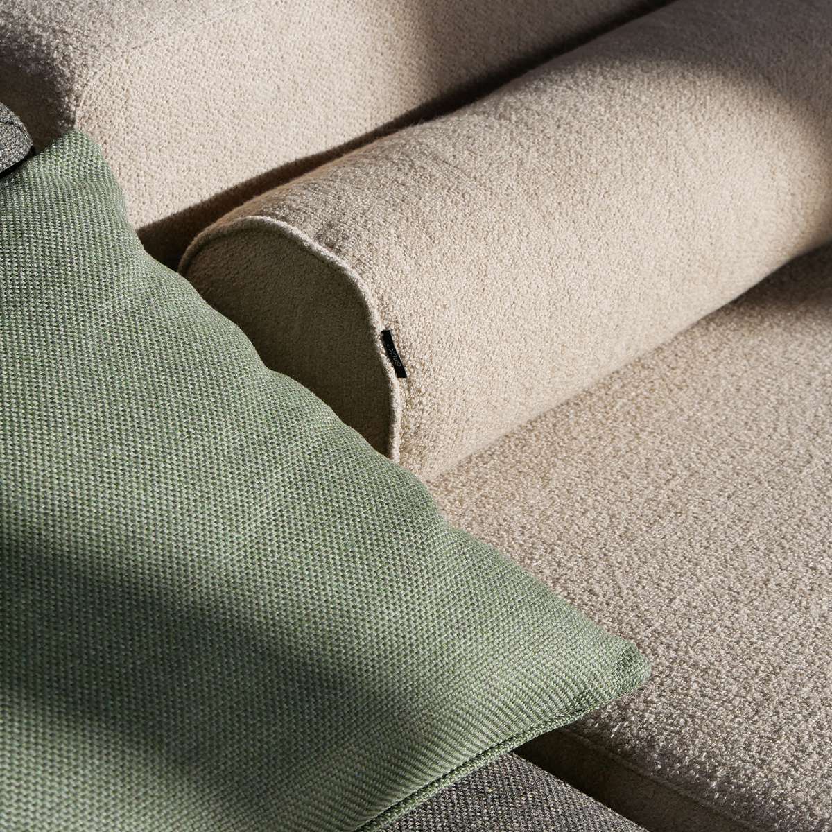 Nærbilde av grønn og beige tekstil på modulbasert utesofa fra sackit med myke puter og skandinavisk design for terrasse og hage