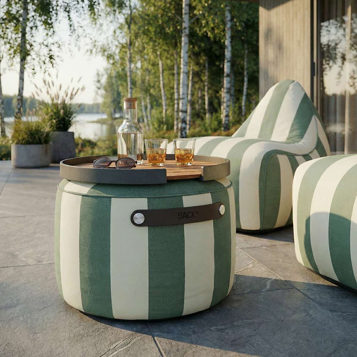 Stripete utendørs puff fra sackit med rundt brett og drikkevarer på en solrik terrasse ved siden av matchende loungestoler
