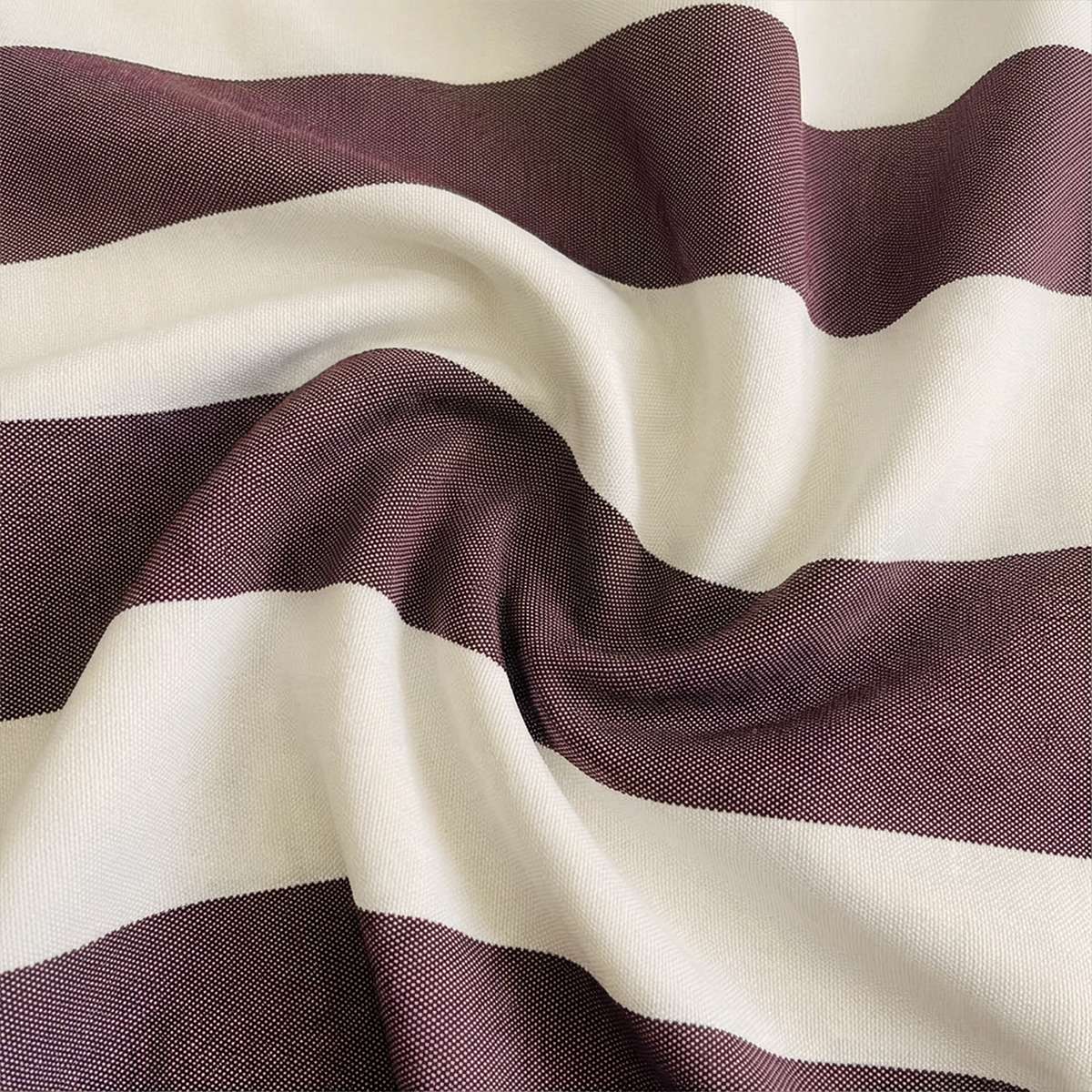 Nærbilde av stripete utendørstekstil i kremhvit og mørk burgunder med myke folder fra sackit pouf outdoor