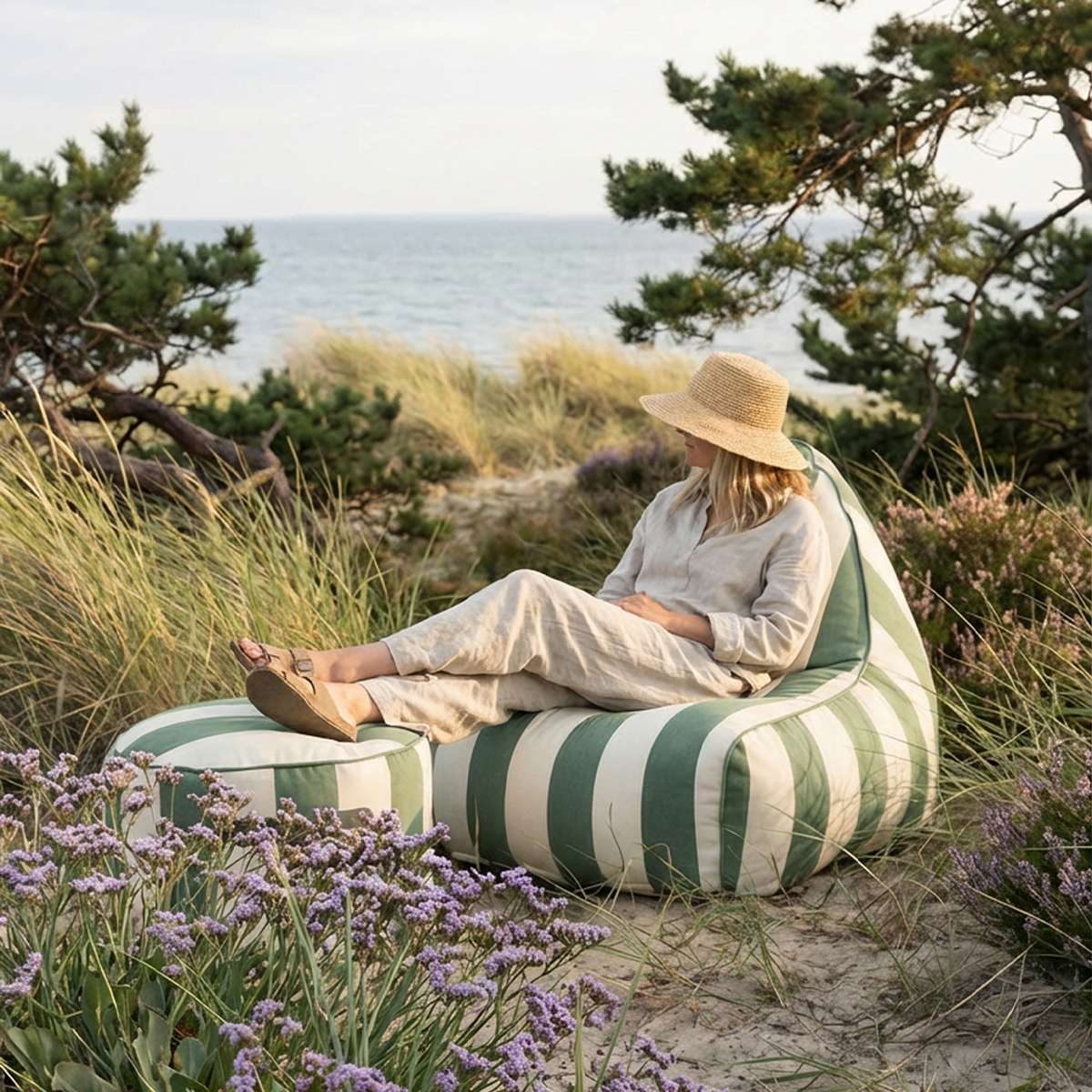 sackit utendørs loungestol med matchende puff i grønne og hvite striper brukt ved kysten omgitt av sanddyner gress og blomster