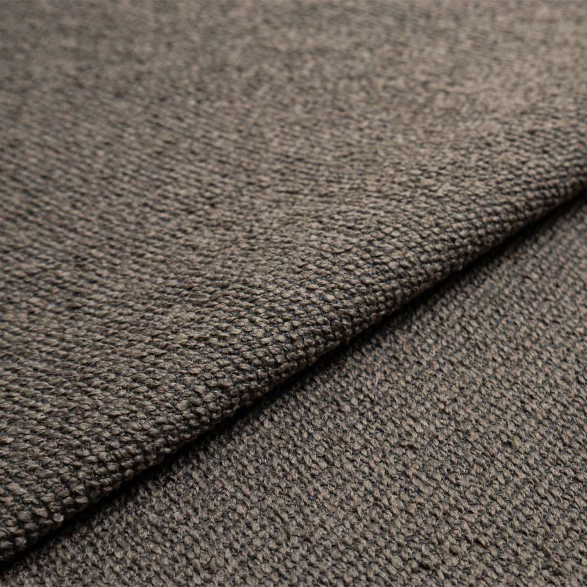 Nærbilde av strukturert gråbrunt møbeltekstil på Fjord sofa fra sackit med myk vev og slitesterk overflate
